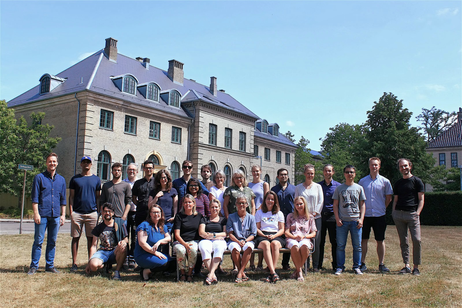 Group photo of the researchers and staff, half sitting on chairs in the front row and half standing behind them